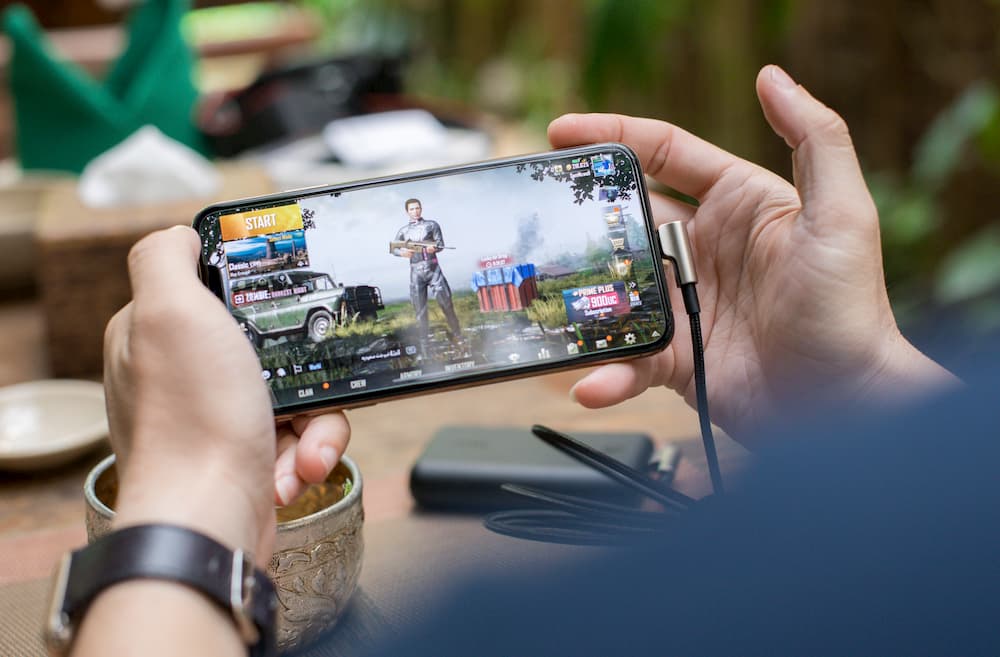 A girl is playing a Pubg-B mobile on her smartphone.